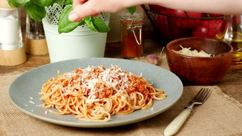Spaghetti Bolognese. Adding cheese to a dish. Slow motion. Hand-sprinkled che Stock Footage 139686736