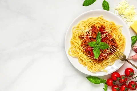 Spaghetti bolognese on a white plate with fork on white marble table. healt.. Stock Photos