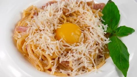 Spaghetti carbonara with egg yolk, bacon, parmesan cheese and basil leaf Stock Footage 87406018