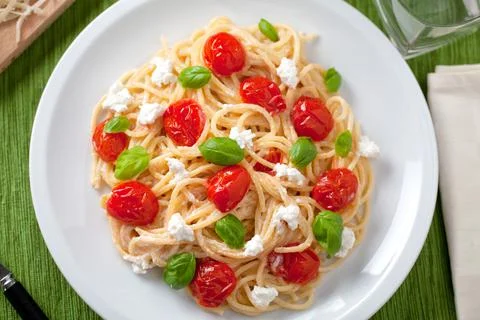 Spaghetti with cherry tomatoes and fresh ricotta on a plate. Stock Photos