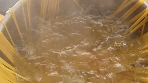 Spaghetti is cooked in a pan with steam and bubbles. Stock Footage 251639421