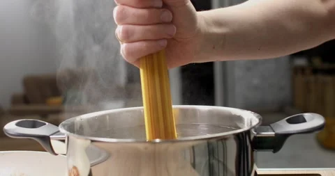 Spaghetti is dipped into a pot of boiling water. Stock Footage 245340257