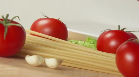 Spaghetti fall on a table between a ripe tomatoes Видео 62681733