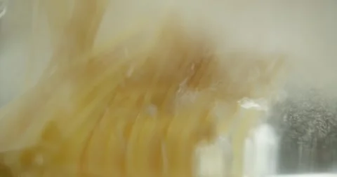 Spaghetti falling into boiling water in a transparent pan on a gas stove. Shot Video stock 316793813