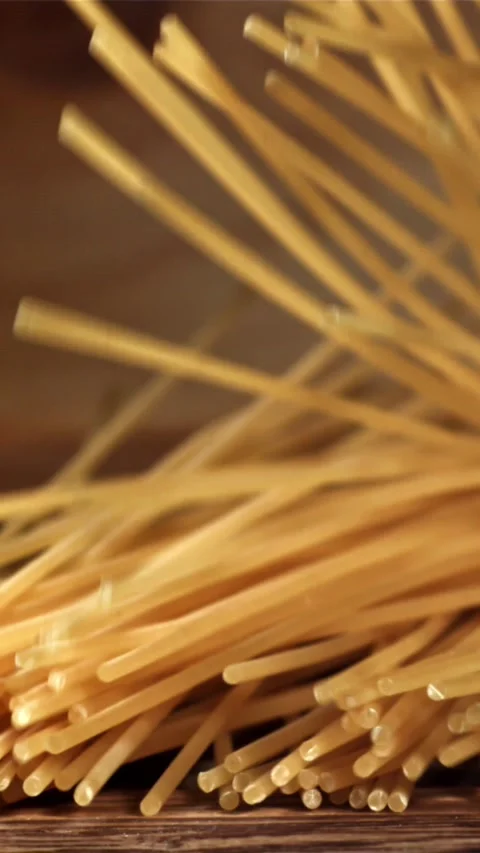 Spaghetti falling on a wooden table. Filmed on a high-speed camera at 1000 fps Stock Footage 335358187