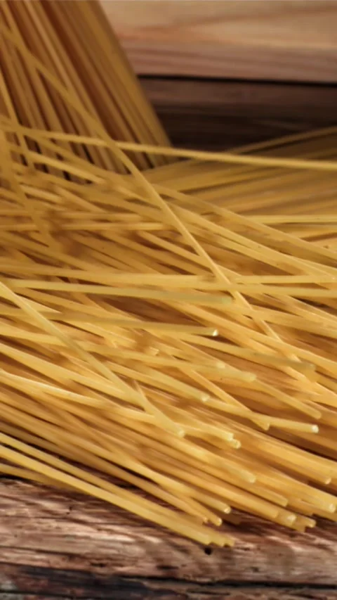 Spaghetti falling on a wooden table. Filmed on a high-speed camera at 1000 fps Stock Footage 335359409