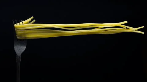 Spaghetti on a fork in front of black background Stock-Fotos