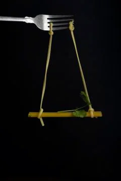 Spaghetti on a fork in front of black background. Swing from spaghetti Stock Photos