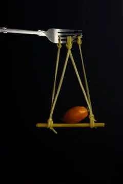 Spaghetti on a fork in front of black background. Swing from spaghetti Stock Photos