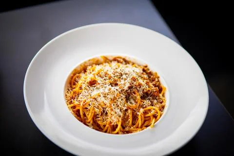 Spaghetti on a fork. Girl use fork with spaghetti. Pasta with red sauce. Stock Photos