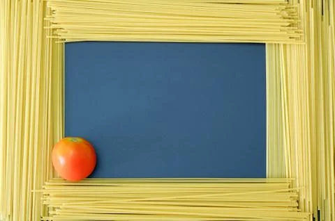 Spaghetti frame with red tomato on dark blue background with free space 스톡 사진