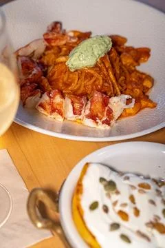 Spaghetti Frutti di Mare on a table set with glass of wine Stock Photos