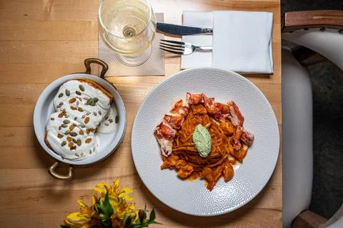 Spaghetti Frutti di Mare on a table set with glass of wine Stock Photos