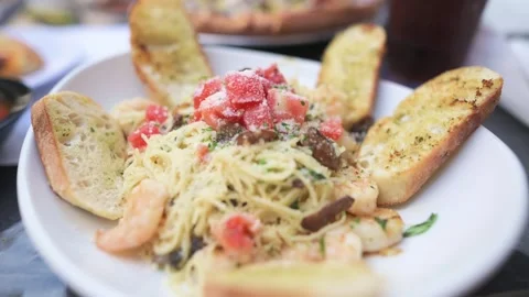 Spaghetti with garlic bread and garnish served at a restaurant Stock Footage 320030681