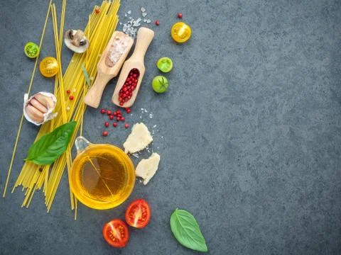Spaghetti with ingredients on dark background flat lay and copy space. Stock Photos