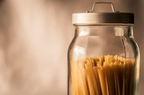 Spaghetti inside a transparent cristal jar with a gray metal cap Stock Photos