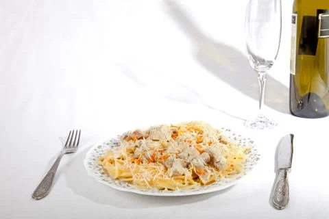 Spaghetti with meat and carrrot on dish, wine glass and bottle Stock Photos