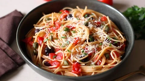 Spaghetti pasta Alla Puttanesca with capers, Kalamata olives, cheese, tomatoes. Stock Footage 208672404