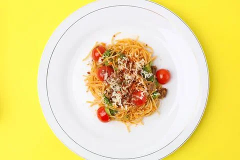 Spaghetti pasta with cherry tomatoes and cheese on a white plate Stock Photos