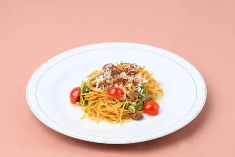 Spaghetti pasta with cherry tomatoes and herbs on a plate Stock Photos