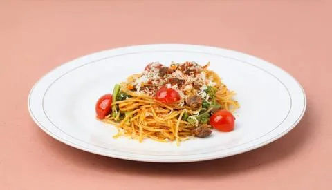 Spaghetti pasta with cherry tomatoes and meat on a plate Stock Photos