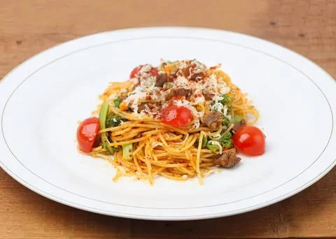 Spaghetti pasta with cherry tomatoes and meat sauce on plate Stock Photos