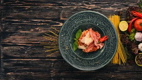 Spaghetti paste with parmesan cheese and tomatoes. Italian cuisine. Top view. Stock Photos