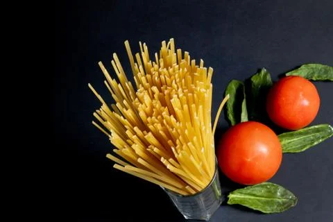 Spaghetti paste, tomato and other products for cooking on dark background top Foto stock