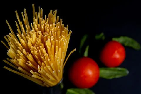 Spaghetti paste, tomato and other products for cooking on dark background top Stock Photos