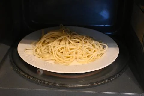 Spaghetti on a plate inside a microwave Stock Photos
