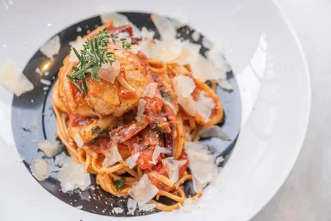 Spaghetti with prawns, sea scallops and parmesan Stock Photos