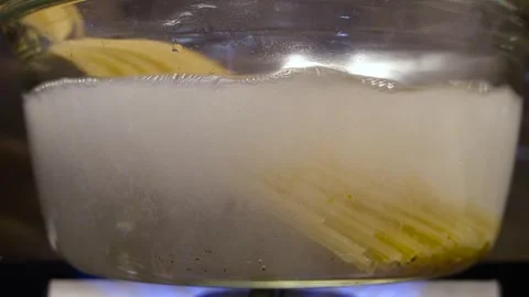 Spaghetti is put into a transparent pan with boiling water. Spaghetti is put Stock Footage 307314252