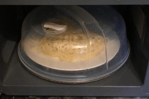 Spaghetti reheating in a microwave Stock Photos
