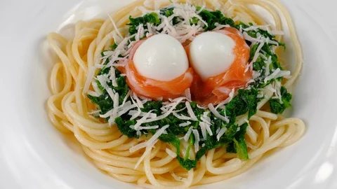 Spaghetti with salmon and quail eggs, green spinach sauce, parmesan cheese Stock Footage 87407317
