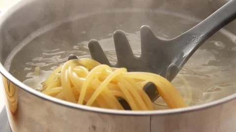 Spaghetti is stirring in a pan with steam and bubbles. Stock Footage 251824454