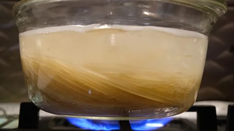 Spaghetti in a transparent pan with boiling water. Spaghetti in boiling water Stock Footage 283815836