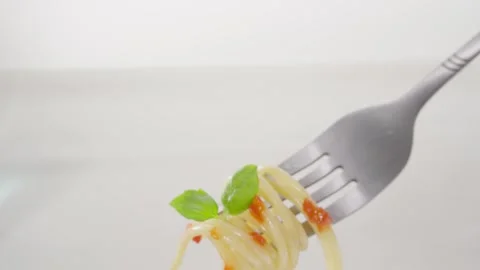 Spaghetti twirled on a fork with tomato sauce and basil. Stock Footage 288829329