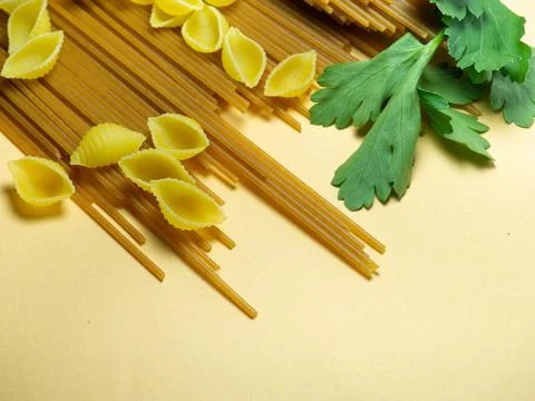 Spaghetti of two types on the table. shells and buckwheat pasta. Italian food Stock Photos