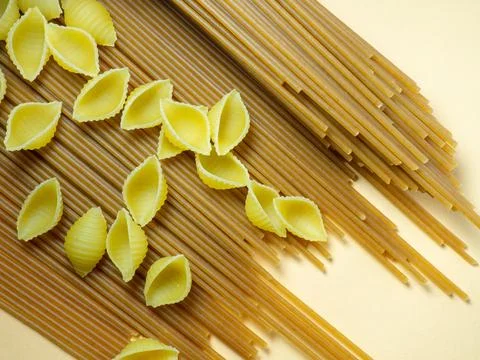 Spaghetti of two types on the table. shells and buckwheat pasta. Italian fo.. Stock Photos