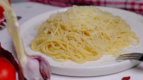 Spaghetti on a white plate with cheese, composition with tomatoes and garlic Stock Footage 167282327