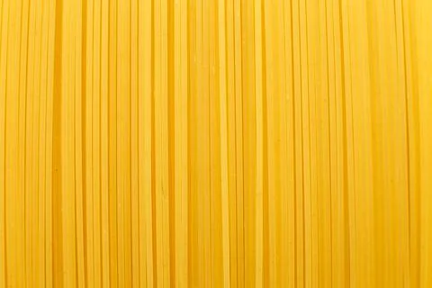 Spaghetti yellow background close. raw pasta macro Foto stock