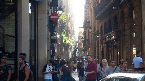 SPAIN BARCELONA JULY 2017: Narrow Barcelona street with tourists walking around Stock Footage