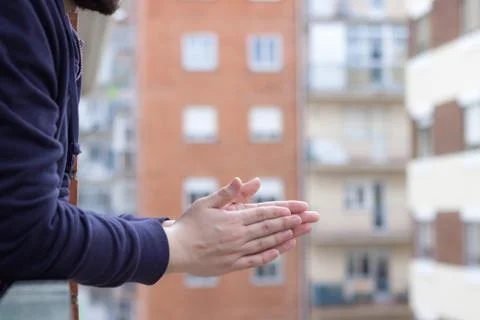 Spain boy clapping from the window of his house Stock Photos