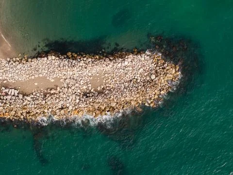 Spain coastal breakwater with triangular jetty tip from drone view Stockfoto's