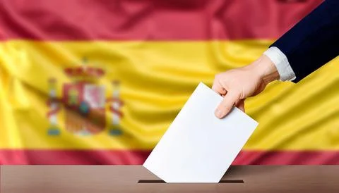 Spain general elections, voting concept. Hand holding ballot in the ballot .. Stock Photos