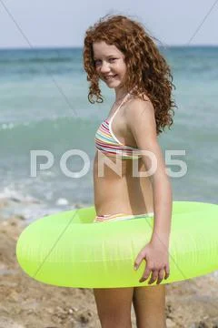 Spain, Girl With Swim Ring On Beach, Smiling