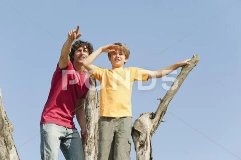 Spain, Mallorca, Father and son standing on tree Stock Photos