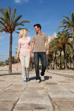 Spain, Mallorca, Palma, Couple walking along allee, smiling Stock Photos