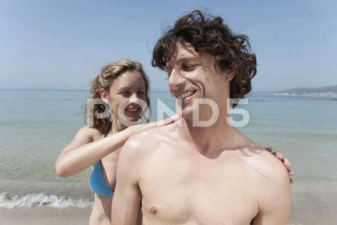 Spain, Mallorca, Woman applying suncream on man's shoulder Stock Photos