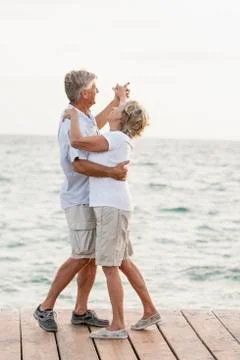 Spain, Senior couple dancing on jetty at the sea Stock Photos